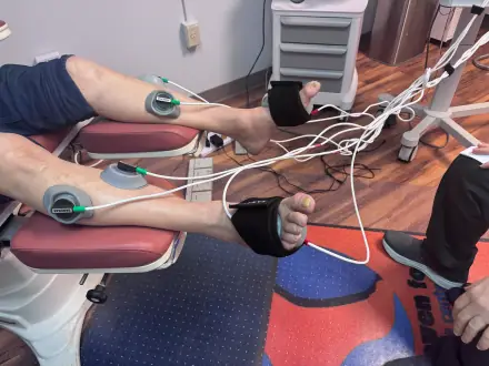 Patient receiving neoGEN electric cell signaling therapy with electrodes applied to the legs and feet